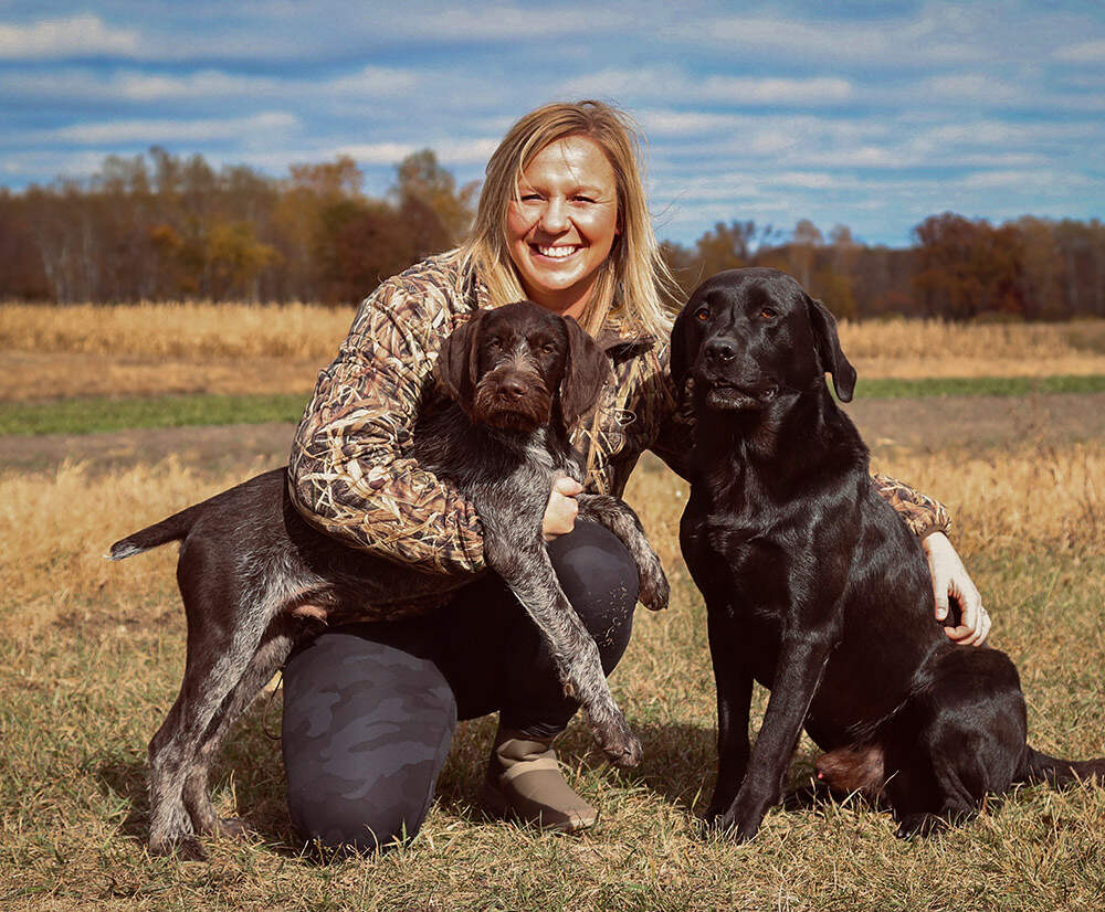 Woman sitting with two dogs outside